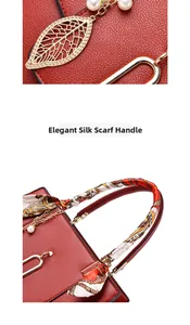 Detail of red lychee leather handbag featuring golden leaf pearl charm and silk scarf handle
