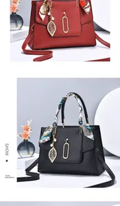Detailed view of荔枝 texture leather handbag featuring a silk scarf handle and gold leaf charm