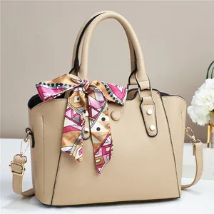 Elegant beige pebbled leather tote bag with geometric print silk scarf and gold hardware