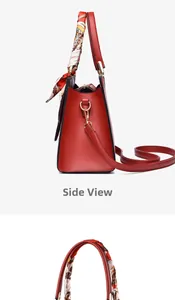 Detail view of red pebbled leather handbag featuring decorative floral silk scarf handle