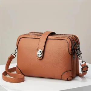Brown litchi pattern leather crossbody bag with triple zipper pockets and metal clasp