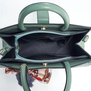 Détail de l'intérieur du sac à main vert à texture pierre montrant les compartiments organisés