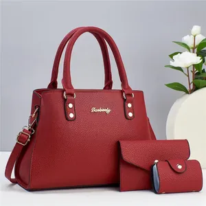 Three-piece red pebbled leather tote bag set including handbag, wallet, and card holder