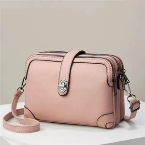 Litchi texture pink faux leather crossbody bag with triple zippers and metal buckle
