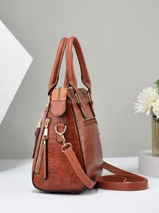 Detailed view of brown crocodile embossed texture on luxury tote with gold hardware
