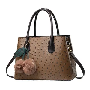Minimalist brown ostrich texture handbag with a plush cherry charm and top handles