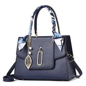 Dark blue grainy leather handbag for women featuring a patterned silk scarf and pearl charm