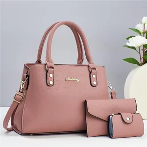 Detailed view of mauve faux leather tote bag set with pebble texture and gold hardware