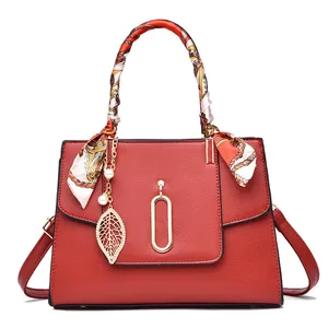 Red pebbled leather handbag for women with silk scarf handle and pearl leaf pendant