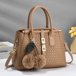 Khaki woven handbag with cherry fur charms and gold hardware for elegant commute style