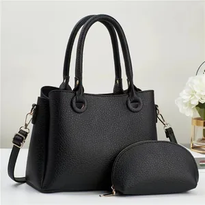 Minimalist black pebble leather tote bag with matching coin purse and gold hardware