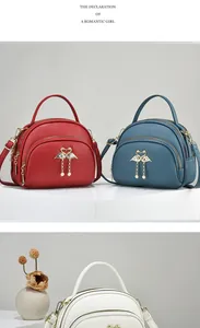 Détail de sacs en cuir grainé avec pendentifs cygne doré et perles élégantes