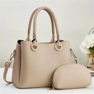 Detail of beige lychee leather handbag set with gold hardware and small pouch