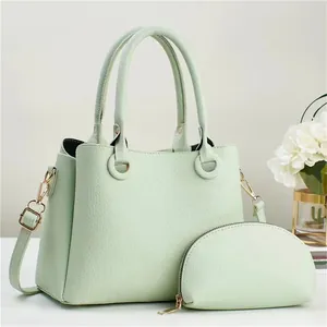 Detail of mint green lychee grain leather tote bag set with golden hardware details