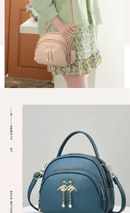 Détail du sac bandoulière avec finitions cygne, pompon perle et trois compartiments zippés