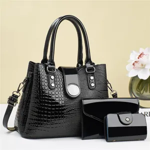 Three-piece black embossed leather handbag set with tote, wallet, and card holder