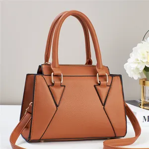 Close-up of caramel litchi grain leather handbag with geometric triangle stitching