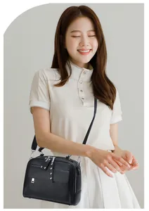 Detail van zwarte crossbodytas van kiezelleder met zilveren studs en decoratieve flap