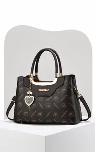 Vue détaillée du grand sac cabas en cuir marron avec imprimés et pendentif cœur