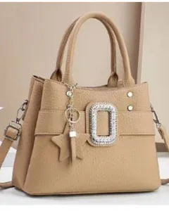 Detail of khaki leather handbag featuring textured lychee grain and square rhinestone buckle