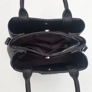 Interior view of black pebbled leather tote with multi-layer compartments and crystal details