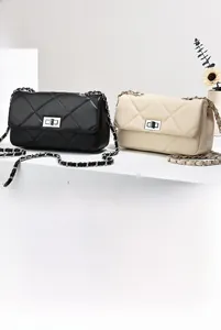 Detail of classic quilted chain bags in black and beige with metallic turn-lock closure