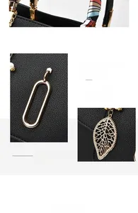 Dettaglio borsa in pelle nera motivo litchi con finiture dorate e ciondolo foglia diamante