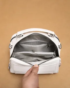Detailopname van beige handtas met chevron voering en meerdere handige opbergvakken