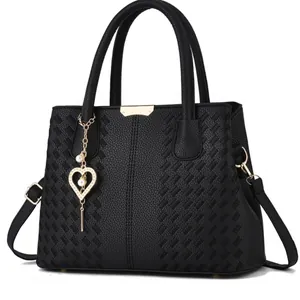 Sac à main noir en cuir grainé avec détails tressés et breloque en forme de cœur