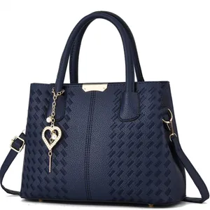 Sac à main bleu foncé en cuir avec broderies et pendentif cœur doré perlé chic