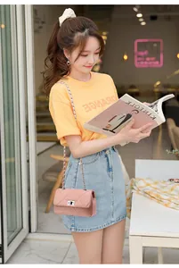 Detail of light pink quilted chain bag styled with casual outfit and leather-woven strap
