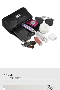 Detail of black quilted leather crossbody bag showing spacious interior with metal clasp