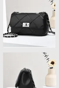 Detail of black quilted faux leather crossbody bag with silver twist lock and chain strap