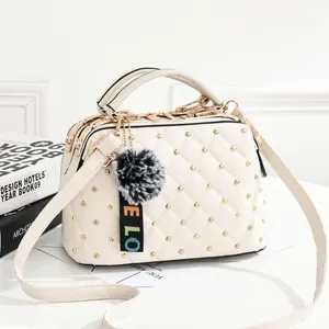 Sac à main matelassé beige chic avec rivets dorés, trois fermetures et charm pompon doux