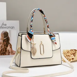 Elegante borsa a mano crema con foulard di seta e ciondolo a foglia dorata raffinata