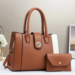 Detail view of caramel brown handbag set with white paneling and golden flower lock