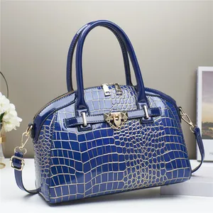 Dettaglio borsa a mano in pelle verniciata blu scuro con stampa coccodrillo e oro