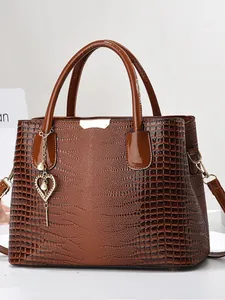 Sac à main marron à motif crocodile avec pendentif cœur doré et bandoulière amovible