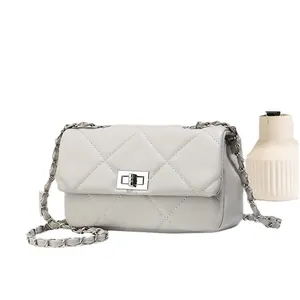 Minimalist beige quilted leather chain bag with silver twist lock on white background