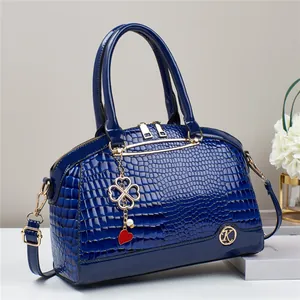 Dark blue crocodile pattern handbag with gold hardware and stylish charm accessories