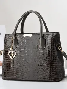 Sac à main gris foncé en cuir verni gaufré avec texture croco et breloque cœur