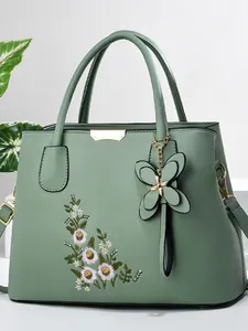 Sage green tote bag for women featuring daisy embroidery and a leather butterfly charm