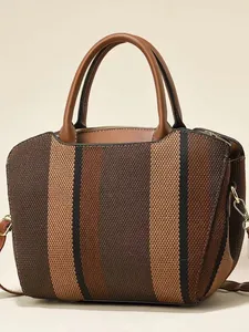 Women's vintage striped canvas tote bag with brown leather handles and gold metal details
