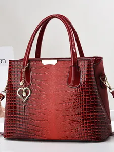 Sac à main bordeaux en cuir embossé crocodile avec pendentif cœur doré et poignées