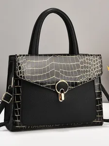 Elegant black tote bag with crocodile texture and golden ring buckle on light background
