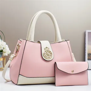 Dettaglio della borsa bicolore rosa e beige con placca dorata a forma di corona