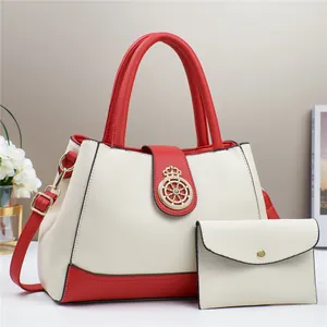 Dettaglio borsa in pelle crema con finiture rosse e fibbia a corona in metallo dorato