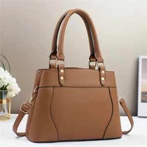 Detailed close-up of brown litchi pattern leather handbag with gold metal hardware