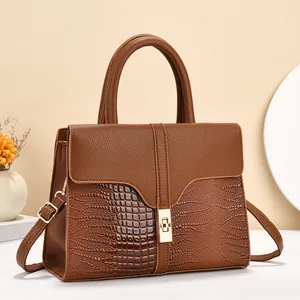 Detail of warm brown tote featuring crocodile print and pebble texture splicing with gold lock