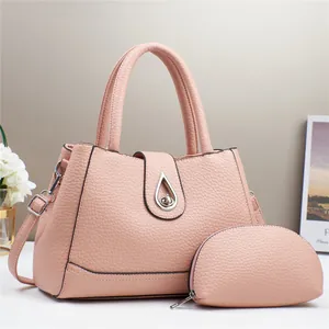 Close-up of pink lychee grain leather handbag set with metal droplet buckle and detail